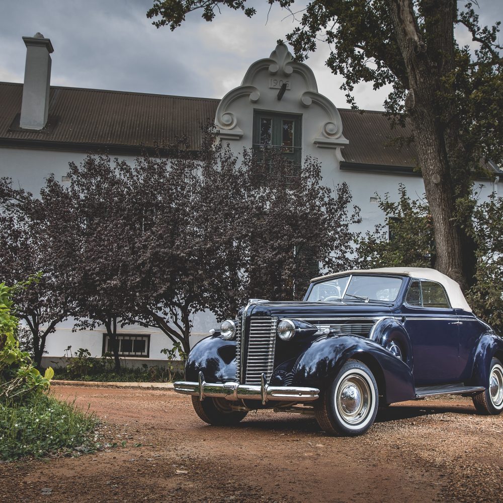 Rolls Royce parked in front of an english gabled residence