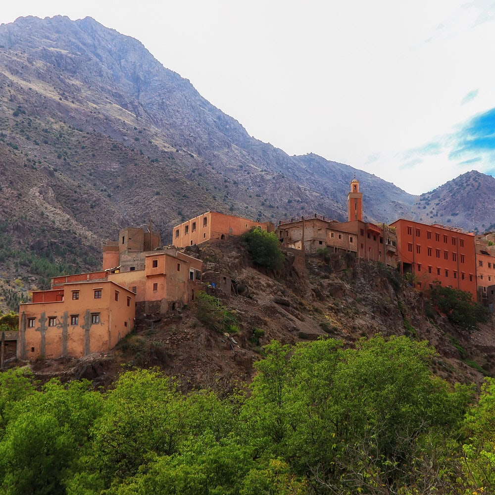 Traditional Moroccan village with clay houses and trees in the background. Authentic rural landscape of North Africa with distinctive architecture and natural surroundings.