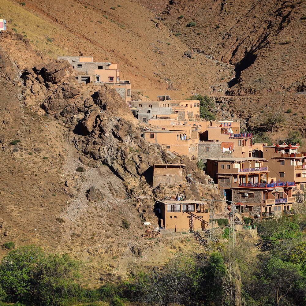 Traditional Moroccan village with clay houses and palm trees in the background. Authentic rural landscape of North Africa with distinctive architecture and natural surroundings.