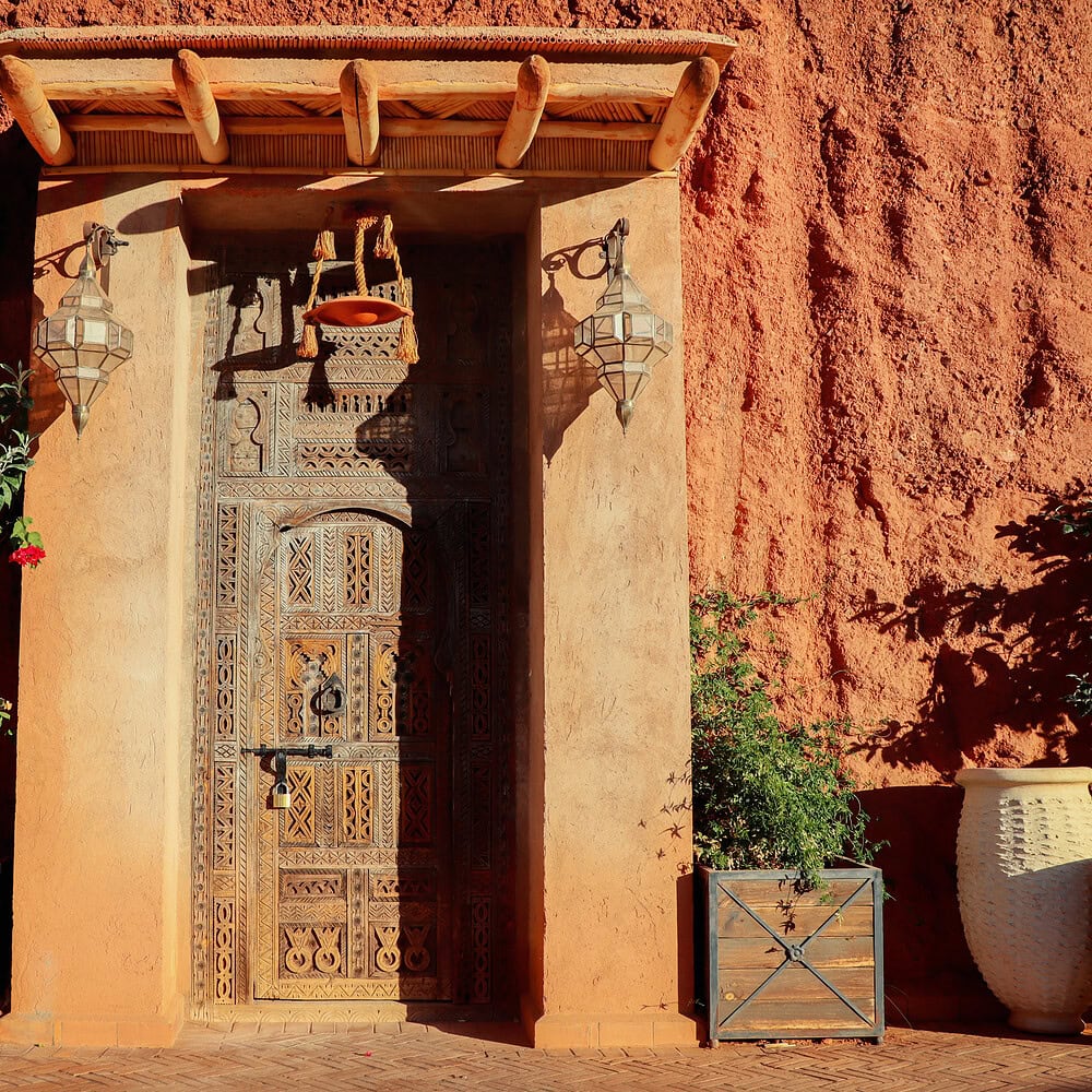Large entrance door in Eastern style with ornaments, carvings, and decorative details. A characteristic architectural element of traditional Eastern buildings and design.