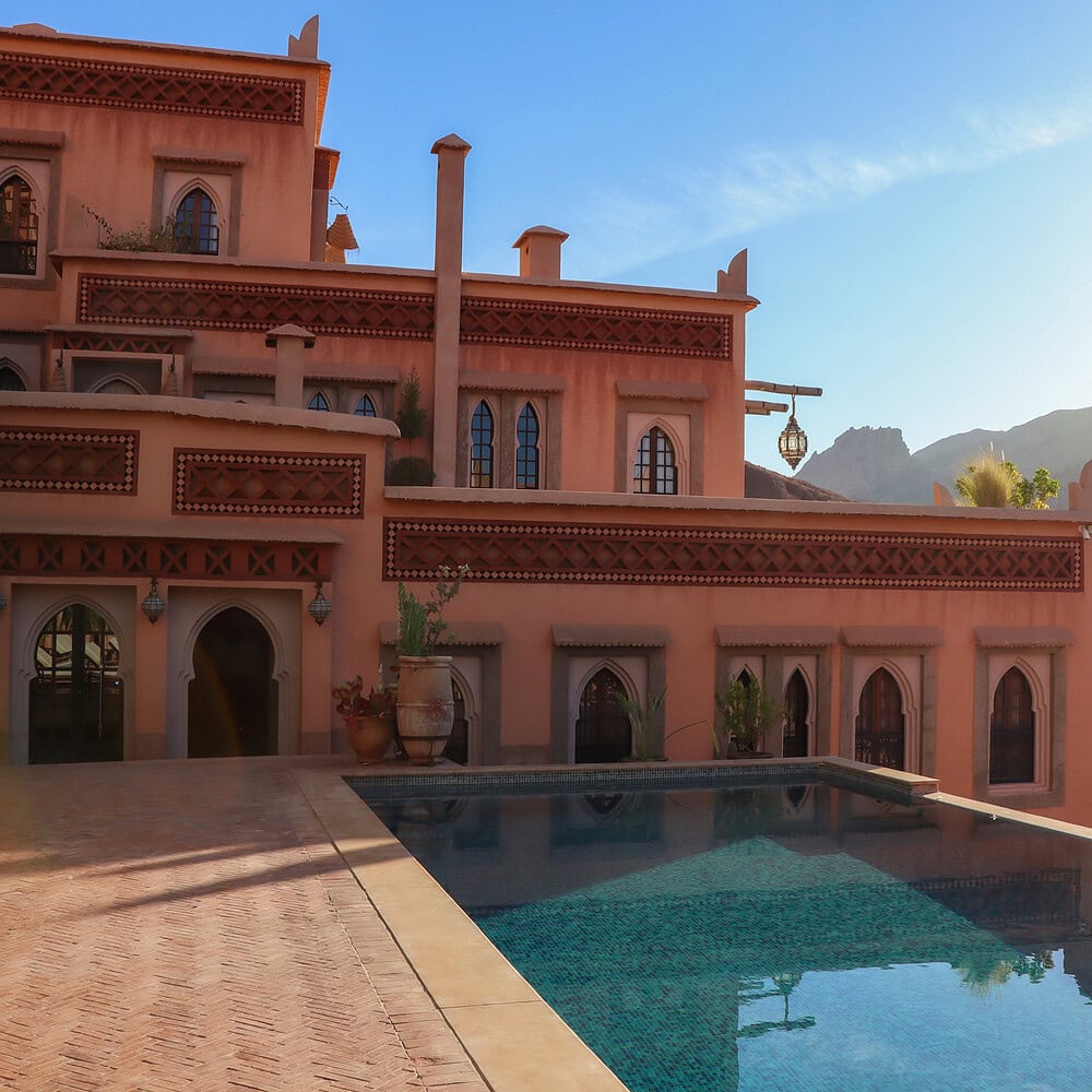 Exterior of a hotel in Moroccan style with a swimming pool. Elegant design inspired by Eastern architecture and Moroccan aesthetics.
