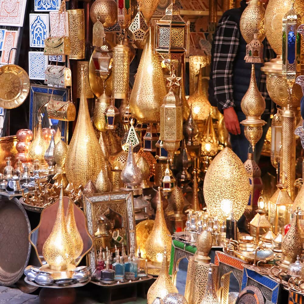 Moroccan decorative lamps close-up at a market. Decorative lighting with ornate patterns and filigree details, characteristic of traditional Moroccan craftsmanship.